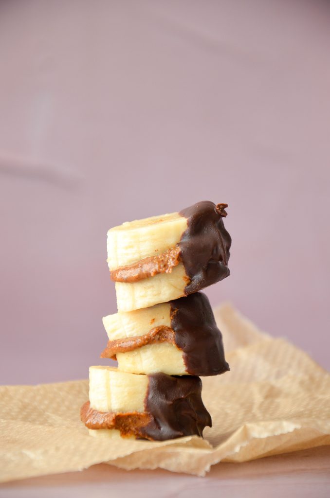 Banana slices covered in chocolate and peanut butter.