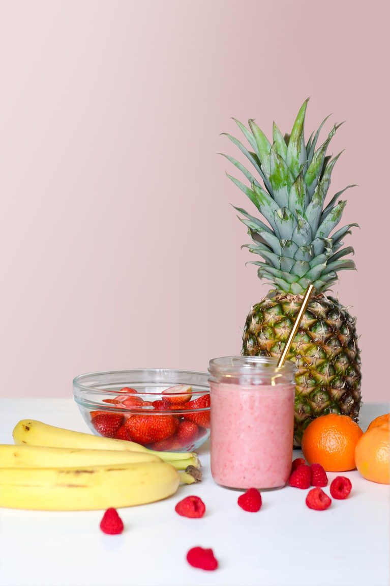 Strawberry Banana Smoothie with fruits in the background.