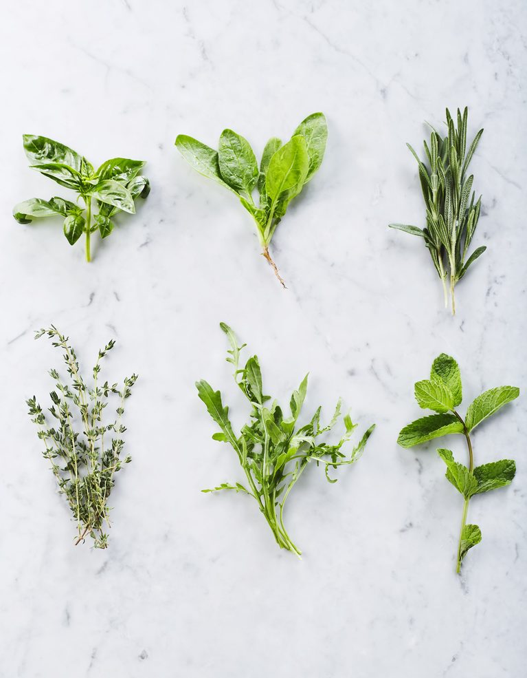 Mixed herbs on a cutting board. Includes basil, parsley, thyme, rosemary and more.